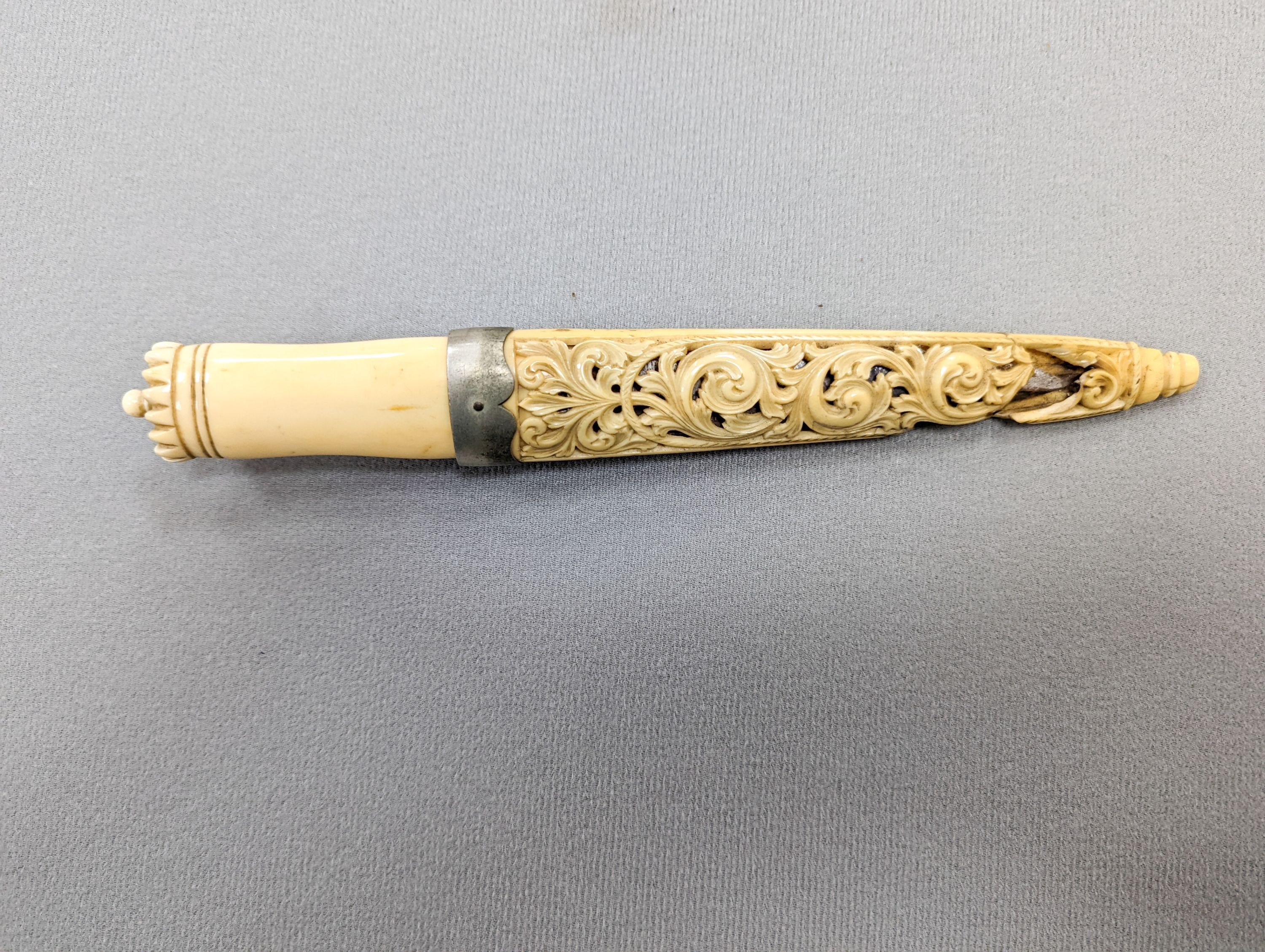 An antique Norwegian marine ivory hunting knife, with carved and pierced scabbard and leather outer sheath, the blade signed Blikstad, Trondhjem, scabbard damaged, overall 26.5cm.